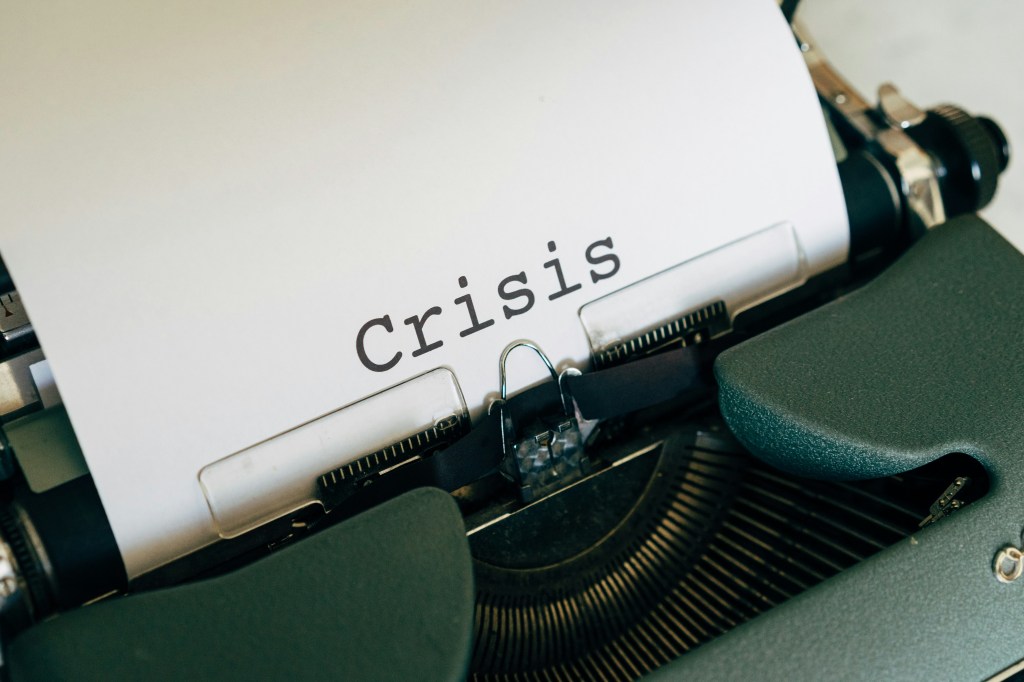 Photo shows typewriter with the word 'crisis' typed on a piece of paper 